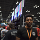 Emory Harris, the owner of Ultrasabers, stands in front of the busy booth at New York Comic Con.